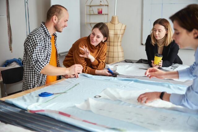 Female tailor explaining something to male near her