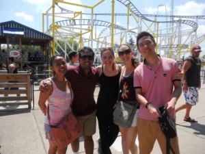 Syracuse students at a theme park smiling at camera