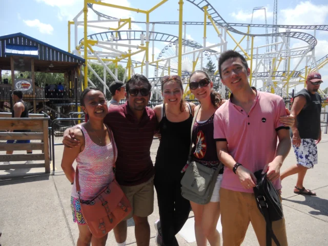 Syracuse students at a theme park smiling at camera