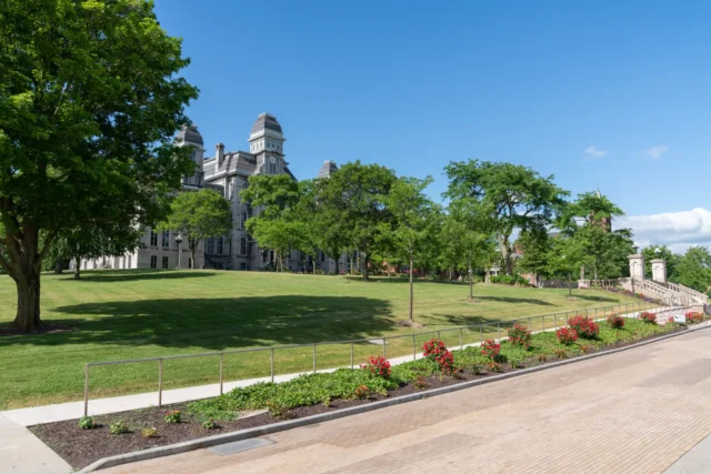 Syracuse campus building with grass and trees