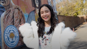 Student in front of Leicester mural