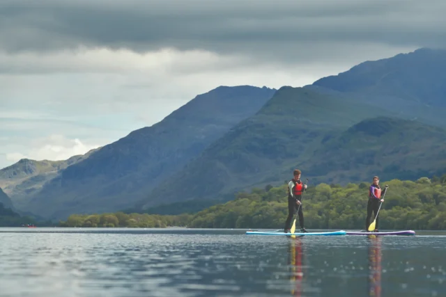 Students paddleboarding on a lake near Bangor University in North Wales