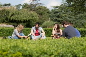 Roehampton students sat outside on grass