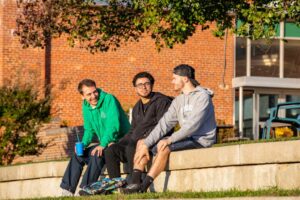 3 students at Mercy sat outside talking