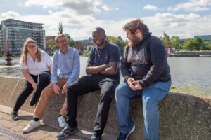 4 students sat outside by the river in Lincoln