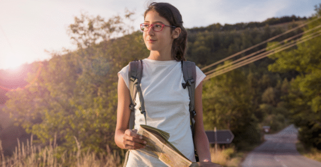 Student with backpack and map on a walk