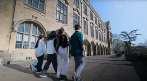 4 students walking in front of building