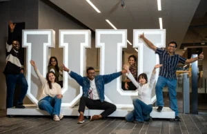 Students infront of UU Logo